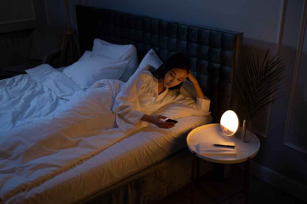 Woman awake at night playing on her phone
